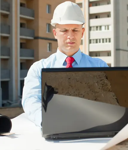 Site supervisor coordinating subcontractors while inspecting a partially framed residential structure